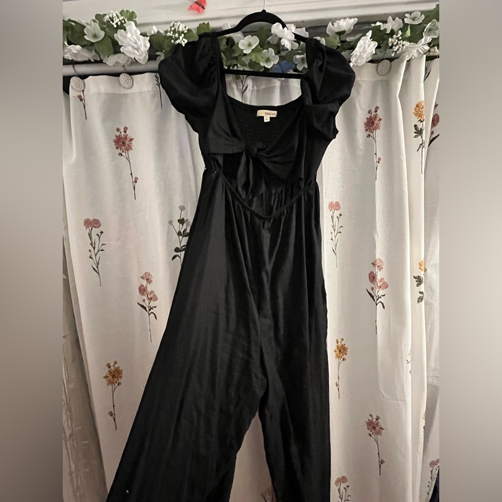 Sleek black romper with cute bow detail and puff sleeves!
